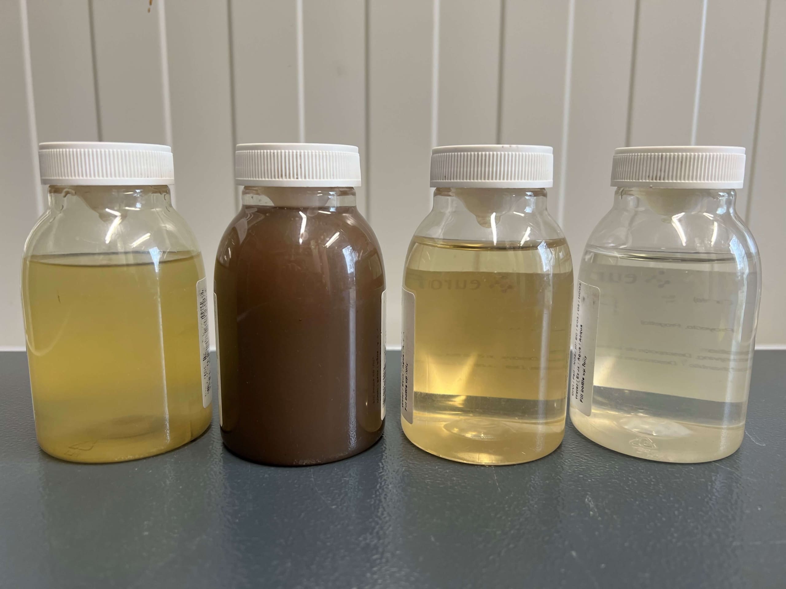 Vuil en gefilterd afvalwater na het zuiveren in monsterpotjes